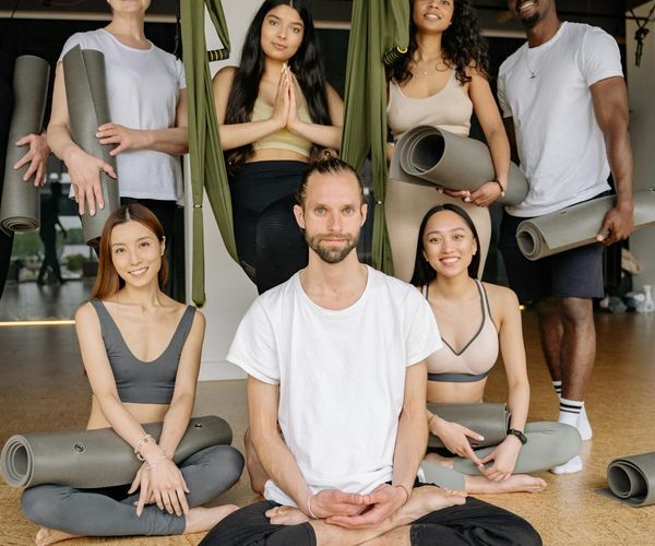 Diverse group of people smiling during a yoga class.